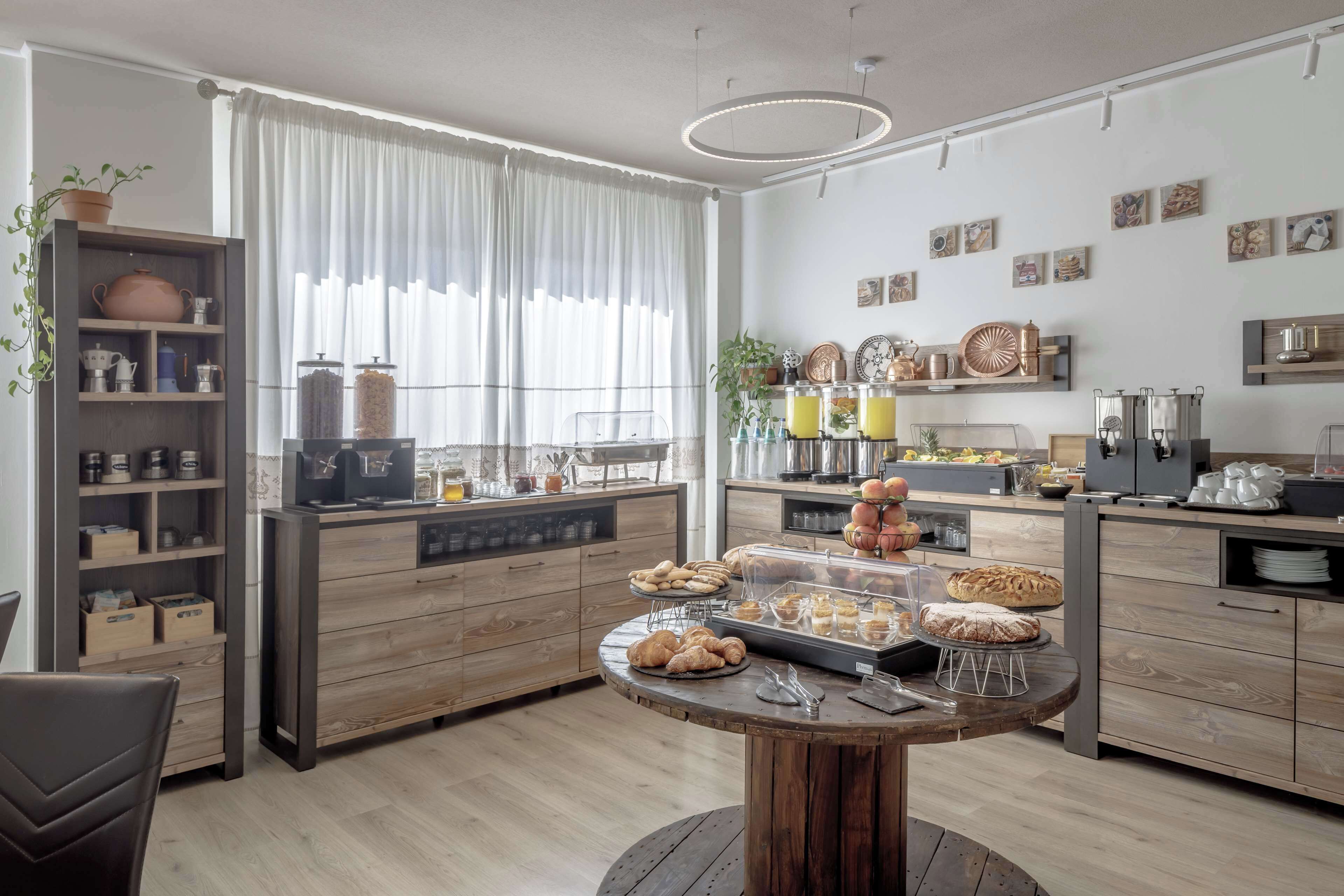 Una cocina moderna con armarios de madera, una isla central con pasteles y diversos electrodomésticos.