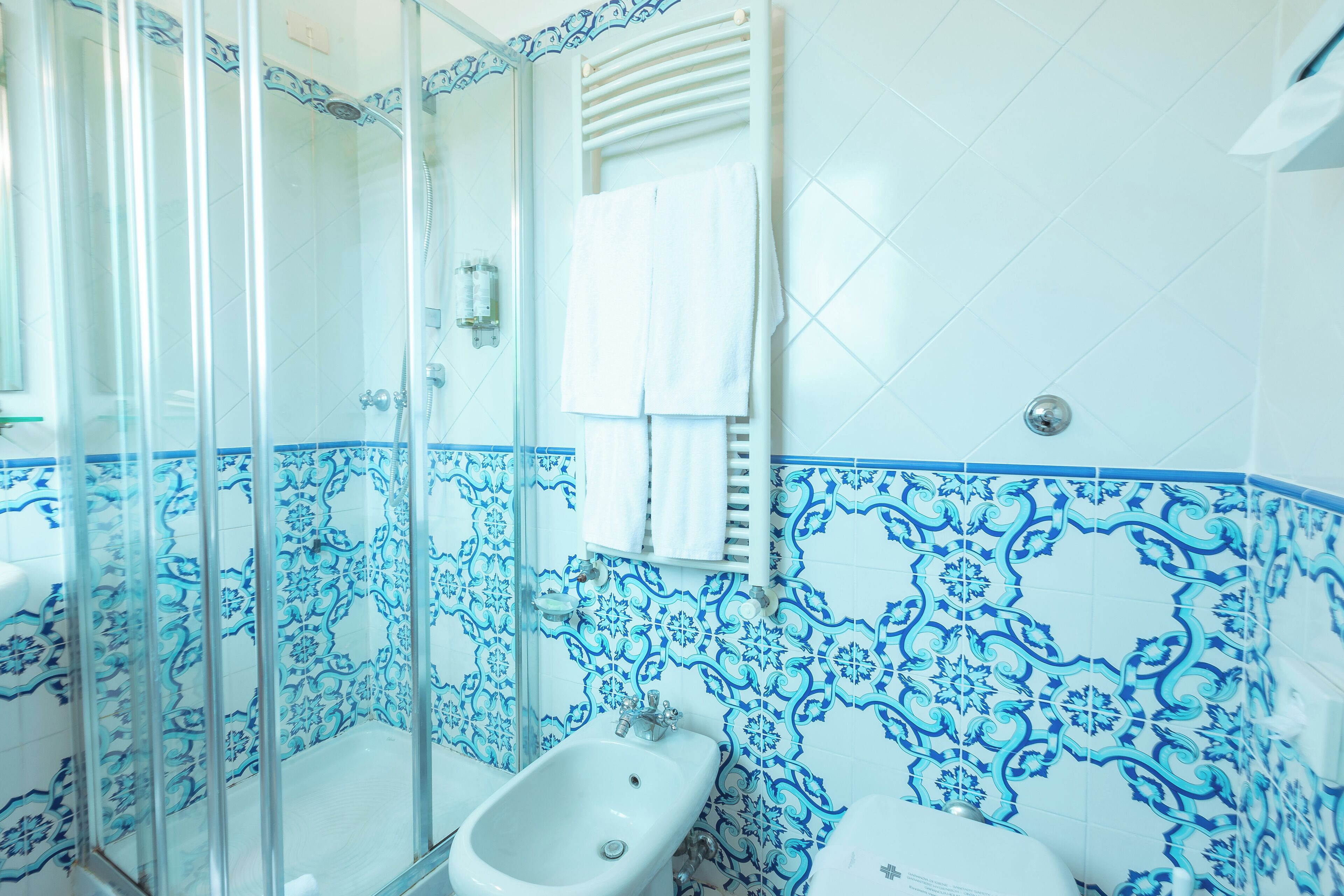A bathroom with a shower, bidet, and toilet.