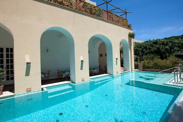 Una piscina al aire libre de temporada, sombrillas