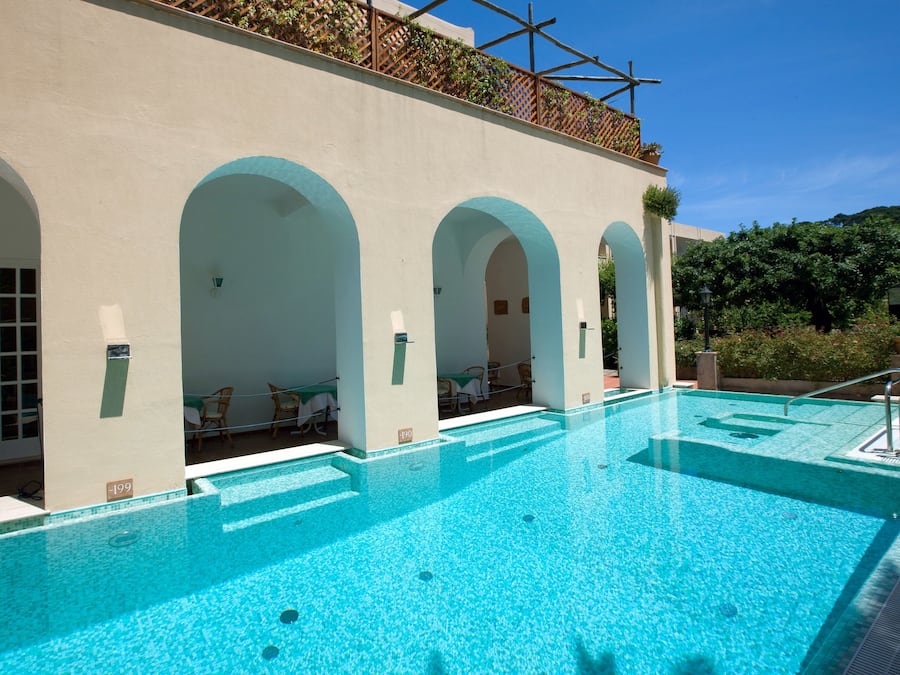 Una piscina al aire libre de temporada, sombrillas