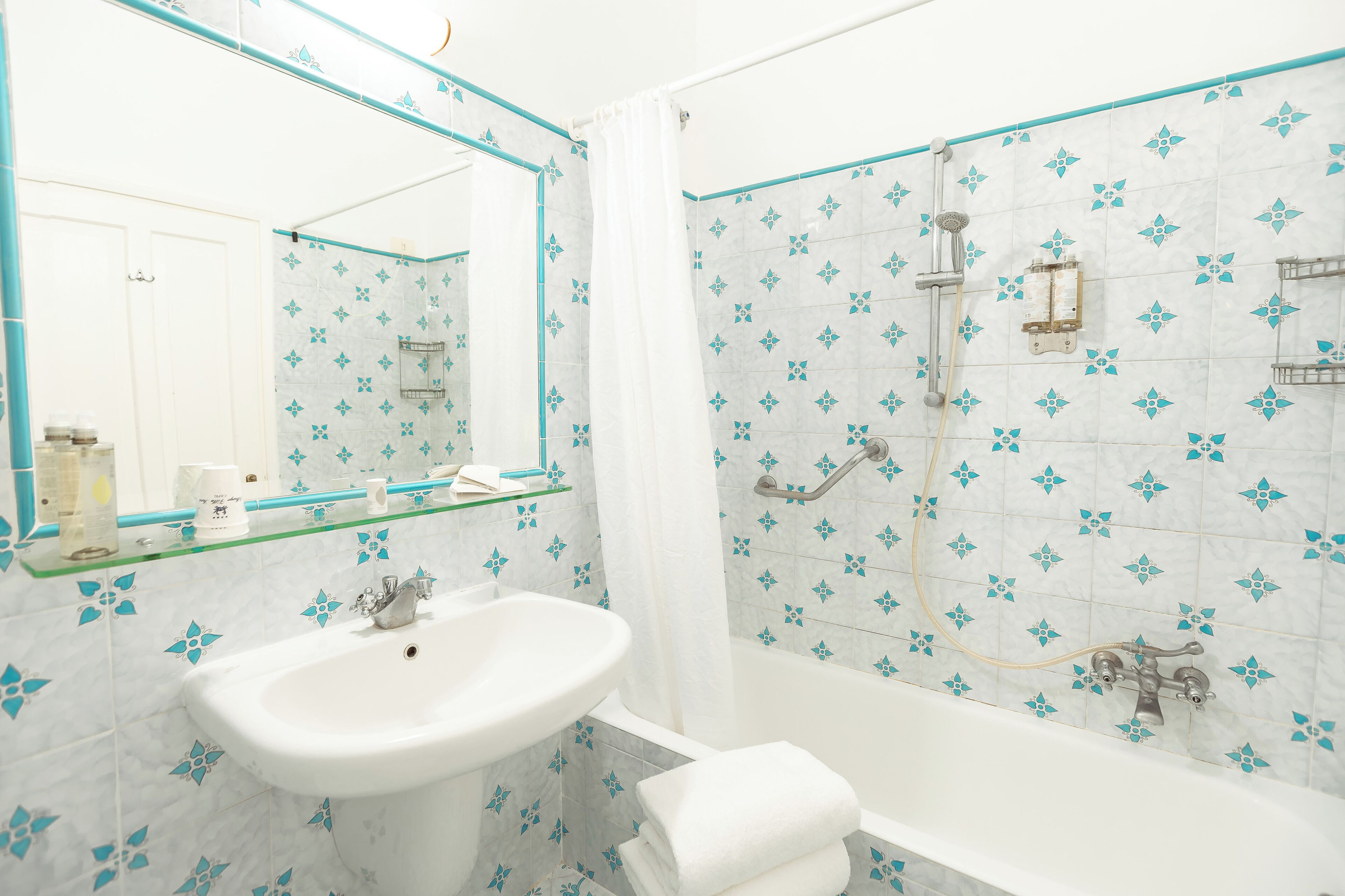 Un baño con lavabo, espejo y ducha.