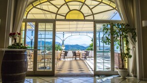 Entrada de hotel con vistas a una terraza y montañas.