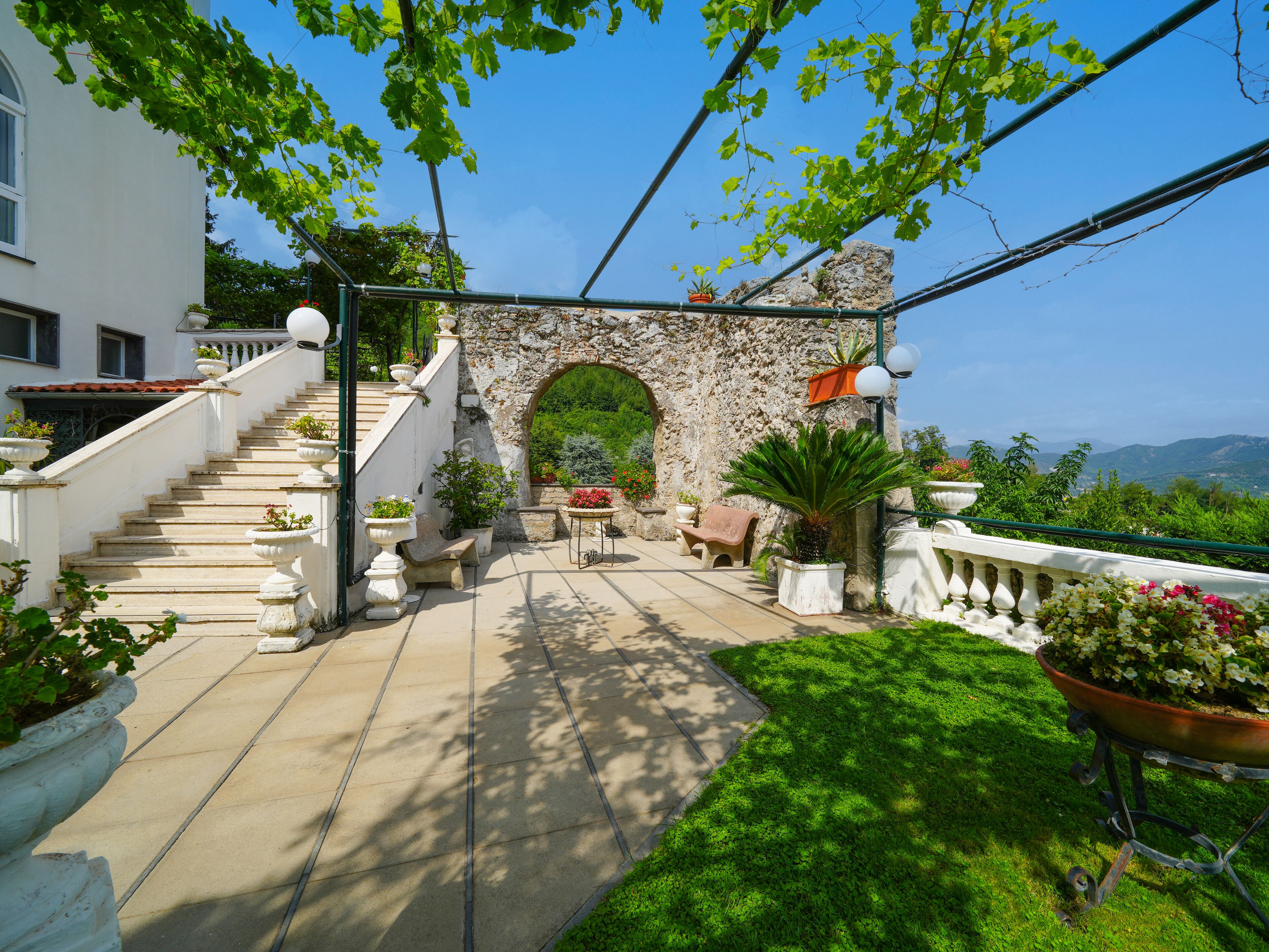 Una escalera de piedra conduce a un espacio exterior cubierto con vistas al paisaje.