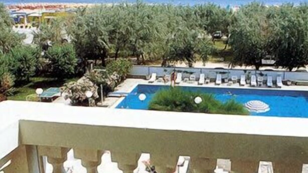 Zona de piscina con sillones de descanso y vistas al mar.