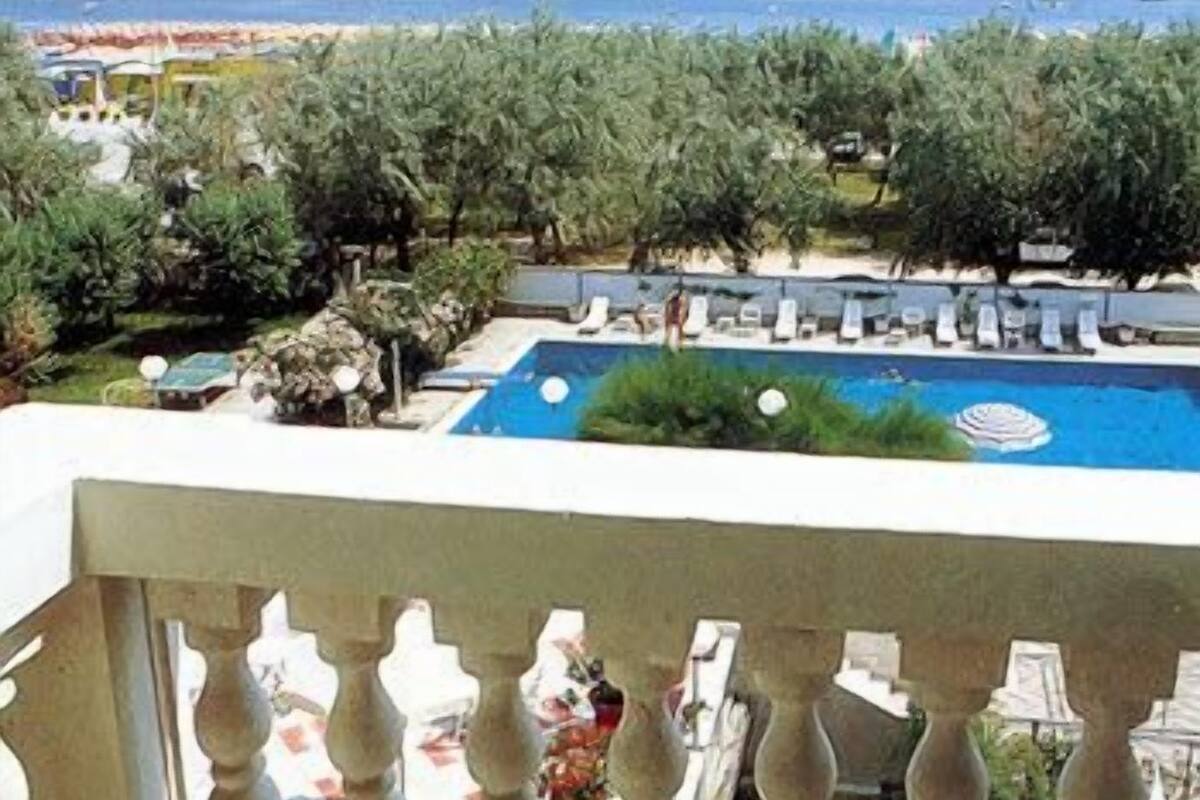 Zona de piscina con sillones de descanso y vistas al mar.