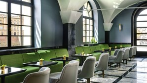 A modern interior with green upholstered seating, black tables, and a marble floor. - Hotel Balestri (Florence)