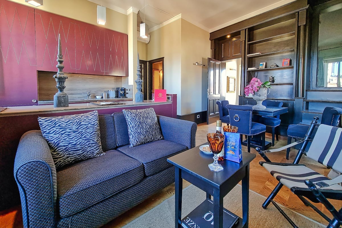 A modern living room with a sofa, a coffee table, and a dining area with chairs.