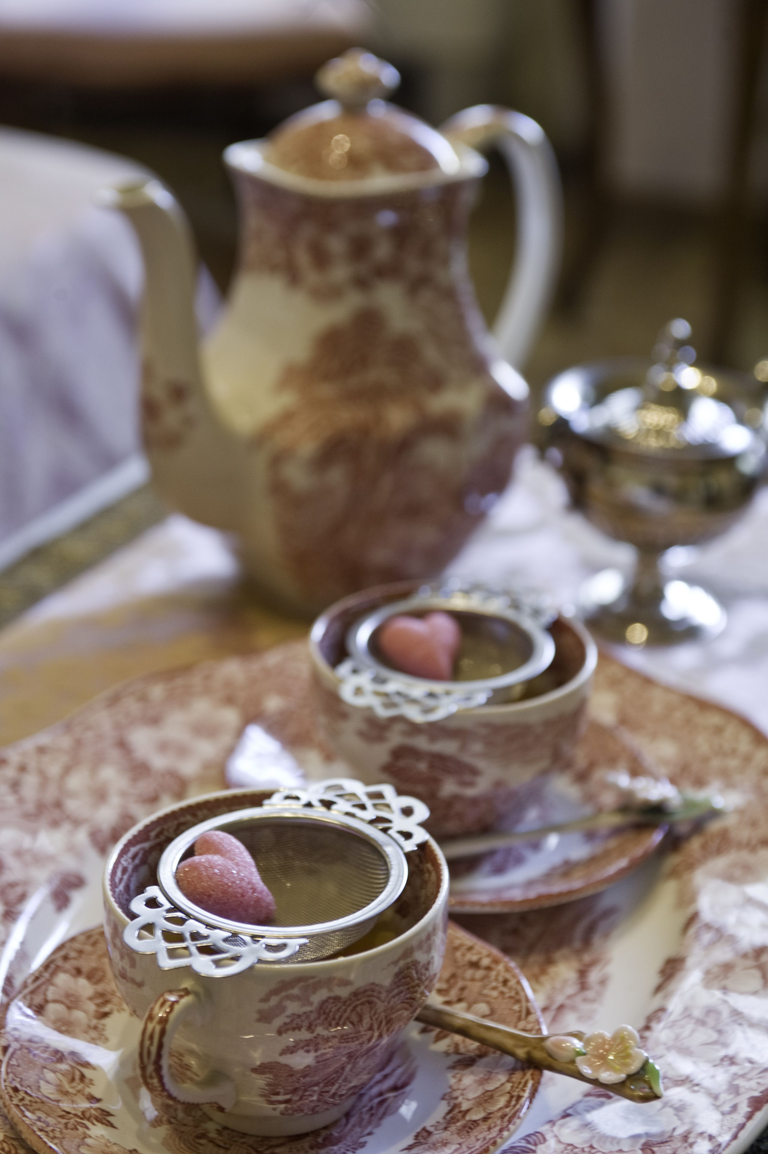A table setting with a teapot, cups, and a sugar bowl.