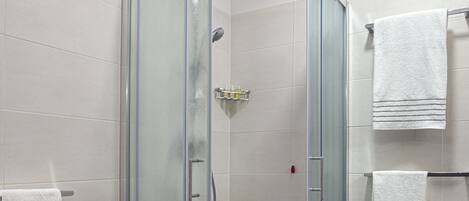 Un bagno moderno con doccia vetrata, lavandino bianco e due portasci.