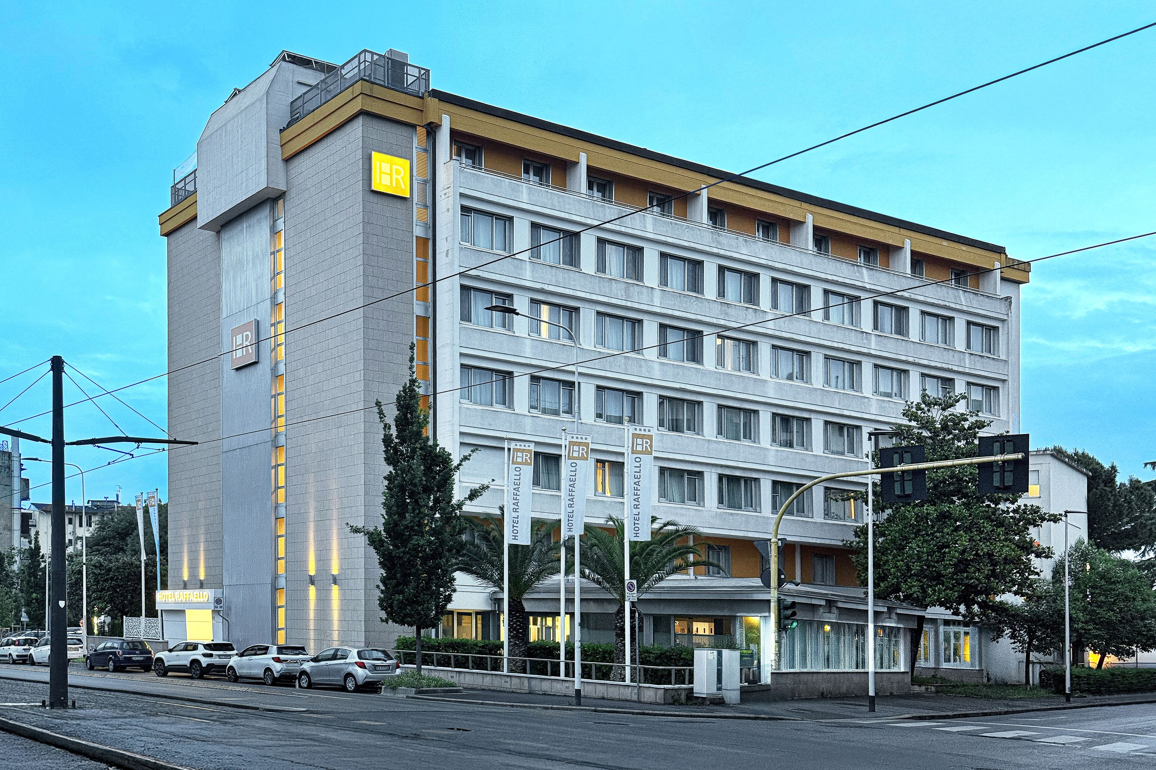 A multi-story hotel with a modern design, featuring a prominent 'Hotel Rafafello' sign.