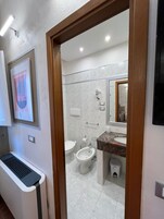 Standaard vierpersoonskamer | Badkamer | Gratis toiletartikelen, een haardroger, een bidet, handdoeken
