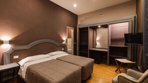 A bedroom with two beds, a desk, a chair, and a TV. - Hotel Unicorno (Florence)