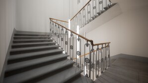 A staircase with a wooden handrail and metal balusters. - Hotel Ariele (Florence)