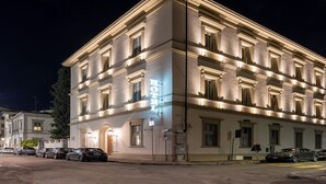 A large, well-lit hotel building with multiple windows and a prominent sign. - Hotel Ariele (Florence)