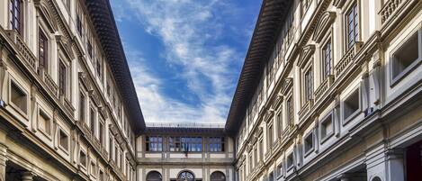 A courtyard with classical architecture, featuring columns and statues.