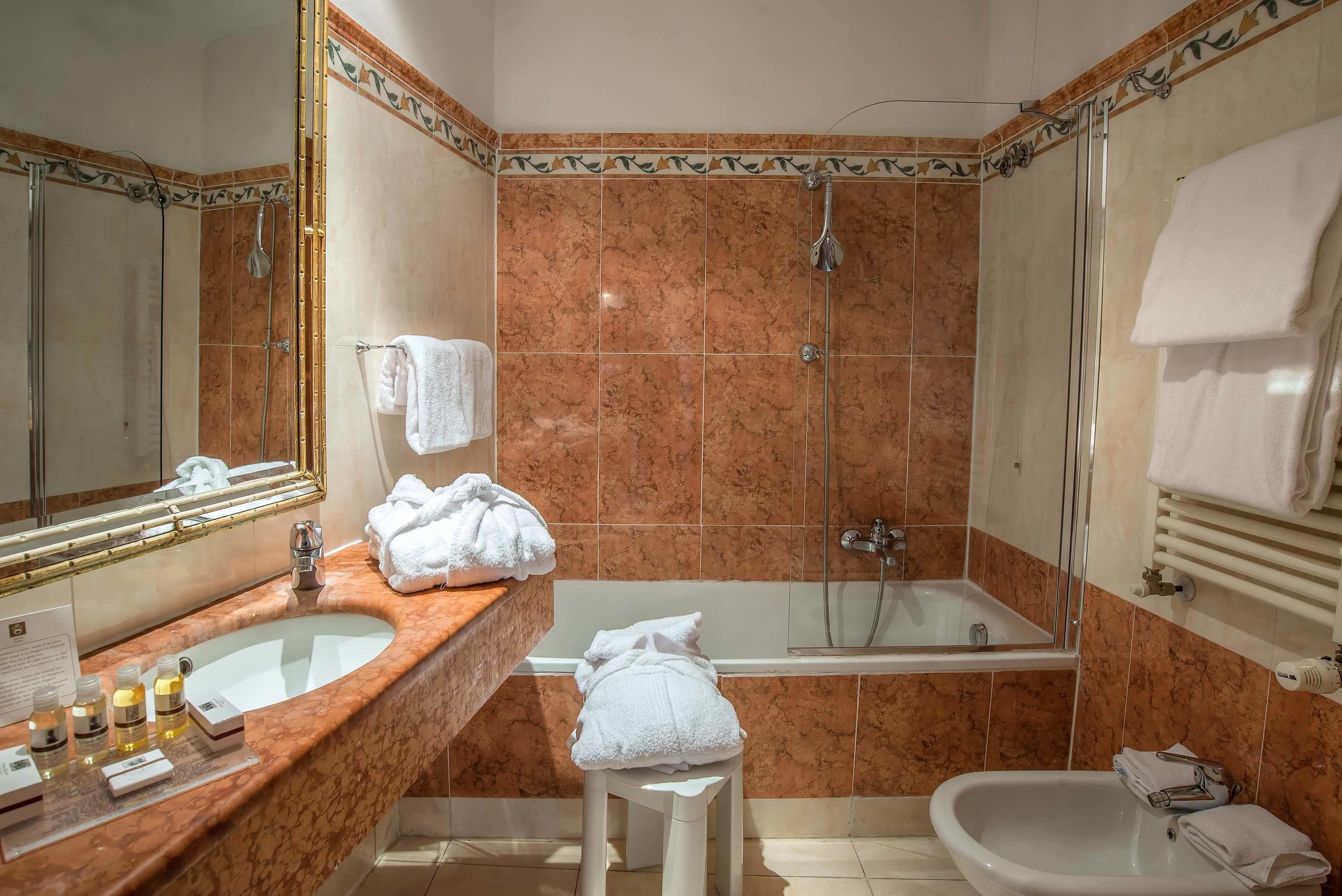 A bathroom with a sink, mirror, shower, and bathtub.