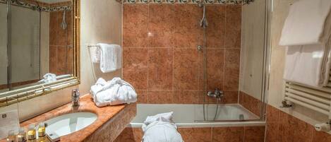 A bathroom with a sink, mirror, shower, and bathtub.