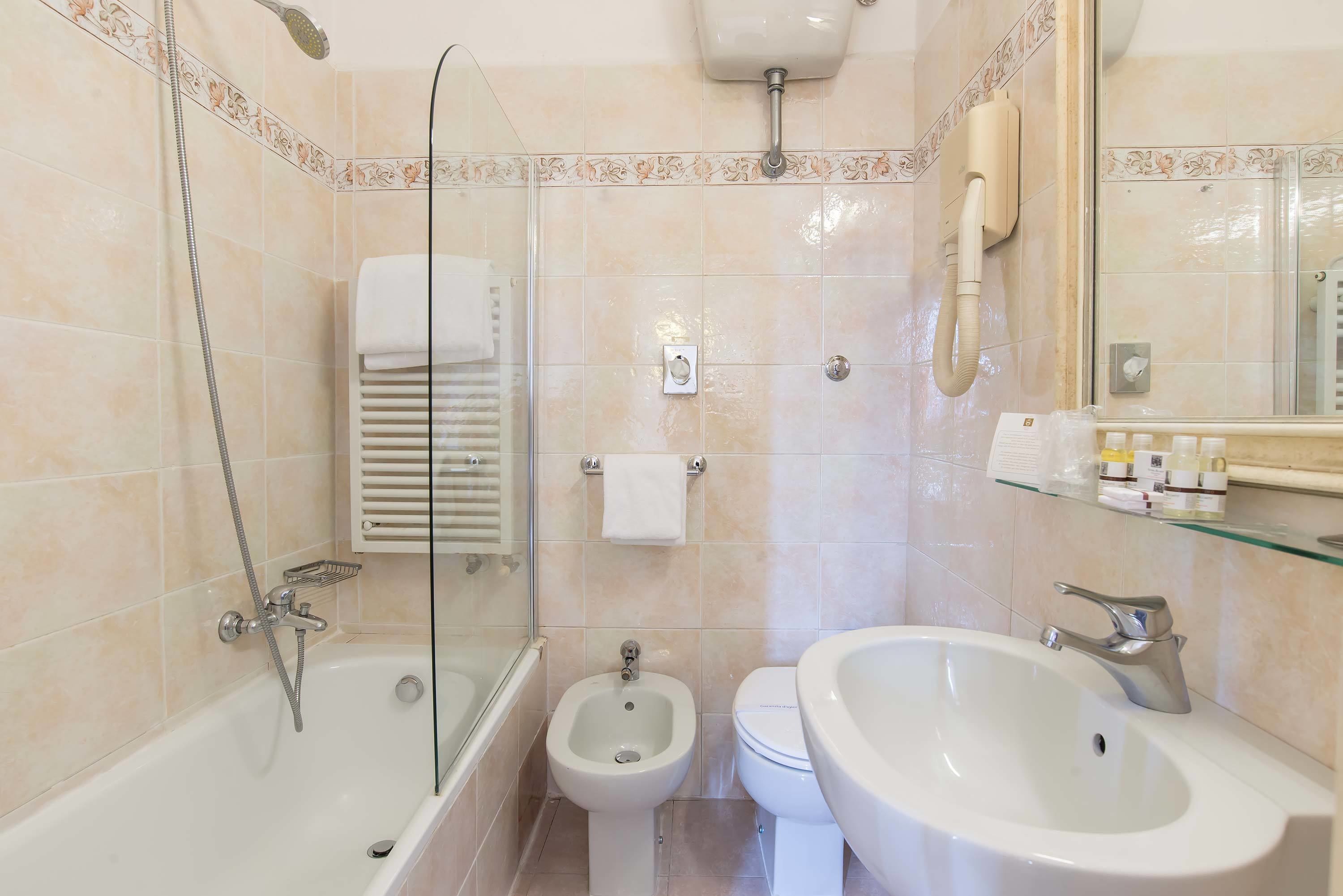 Une salle de bain moderne équipée d’une baignoire, d’un bidet, de toilettes et d’un lavabo.