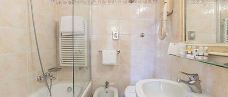 Une salle de bain moderne équipée d’une baignoire, d’un bidet, de toilettes et d’un lavabo.
