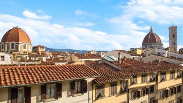 Paesaggio urbano con edifici storici, strutture a cupola e un'imponente torre.