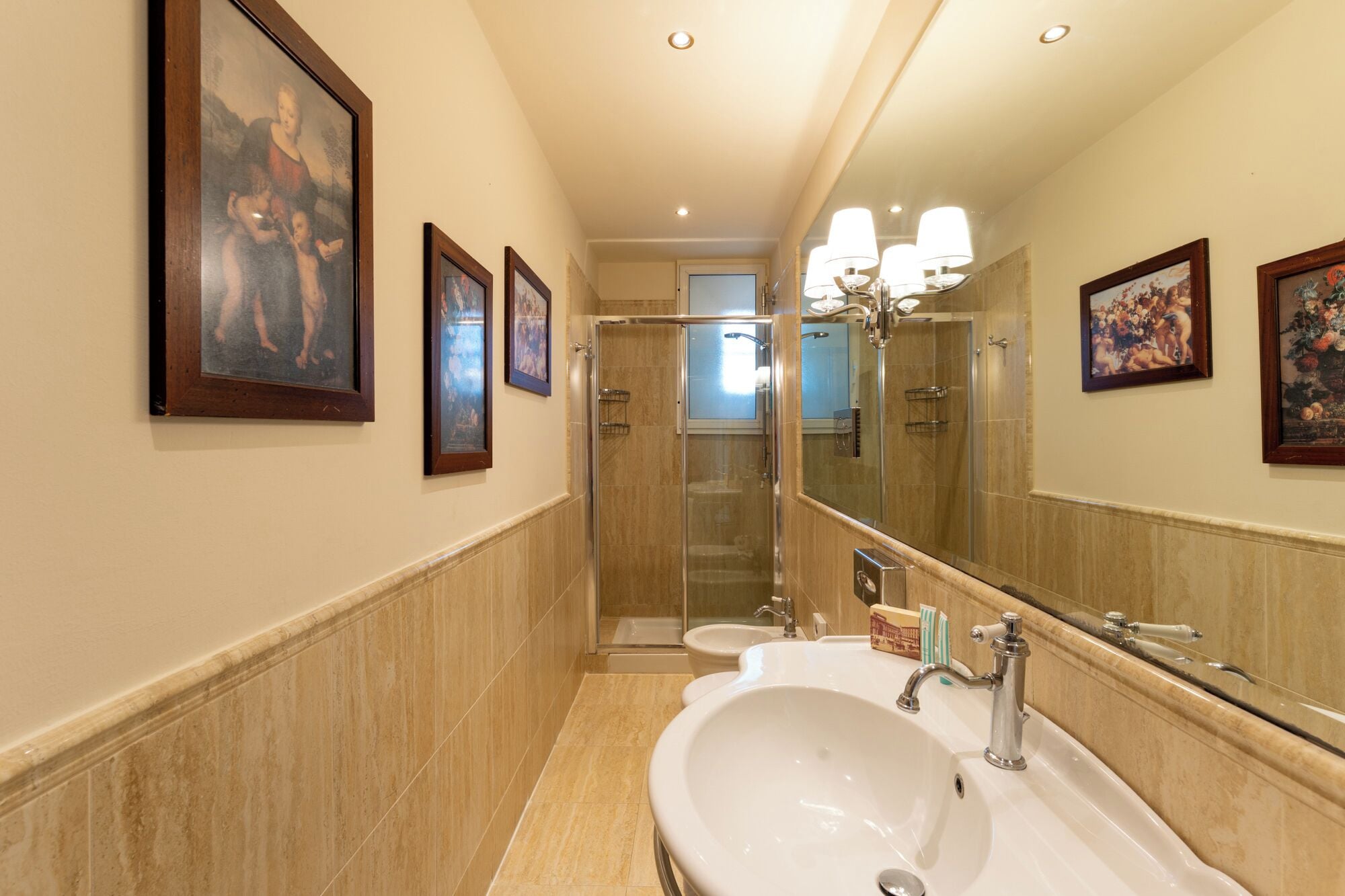 A hotel bathroom with a large mirror, a sink, and a shower.