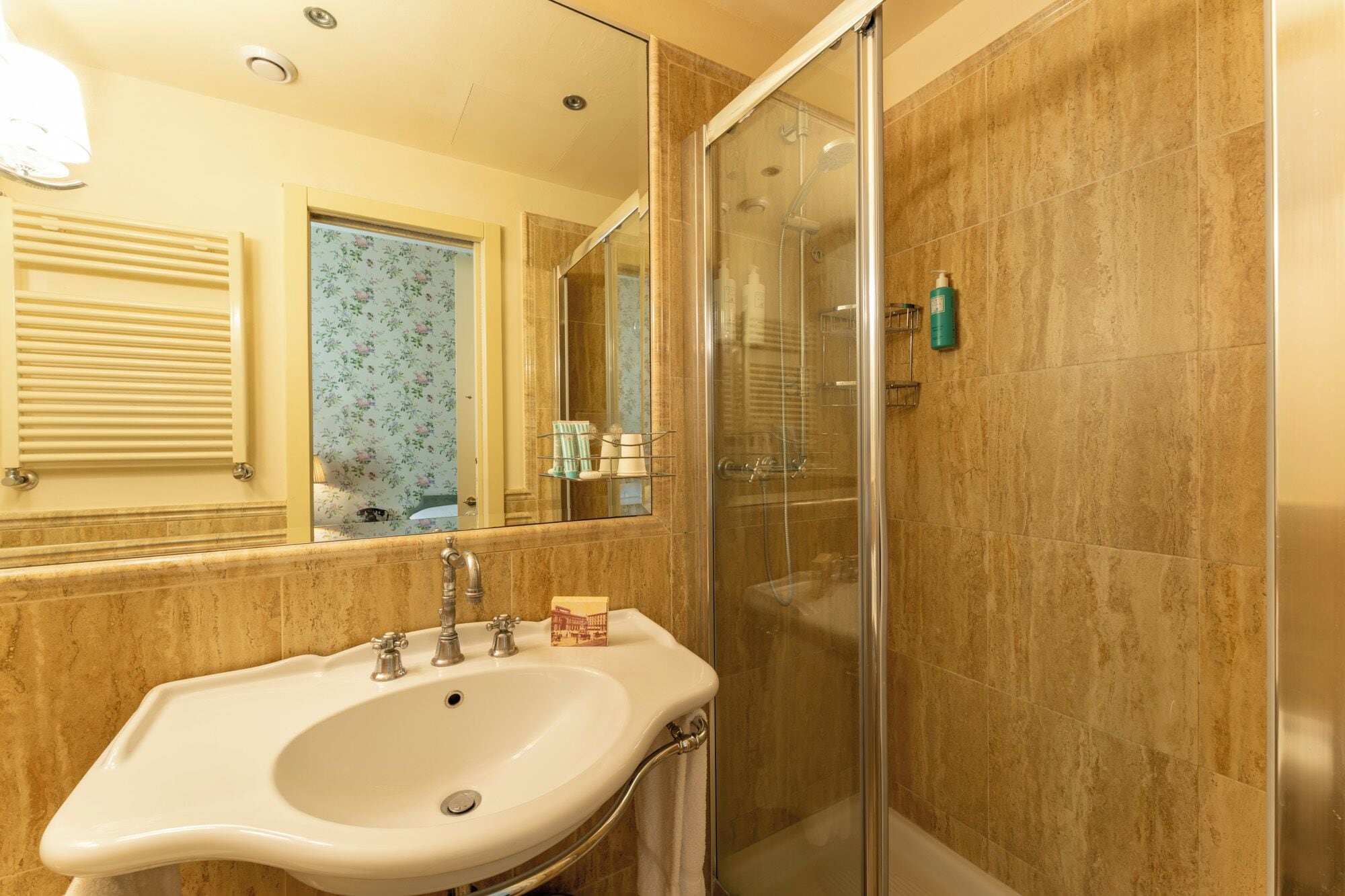 A bathroom with a sink, a glass shower enclosure, and a mirror.