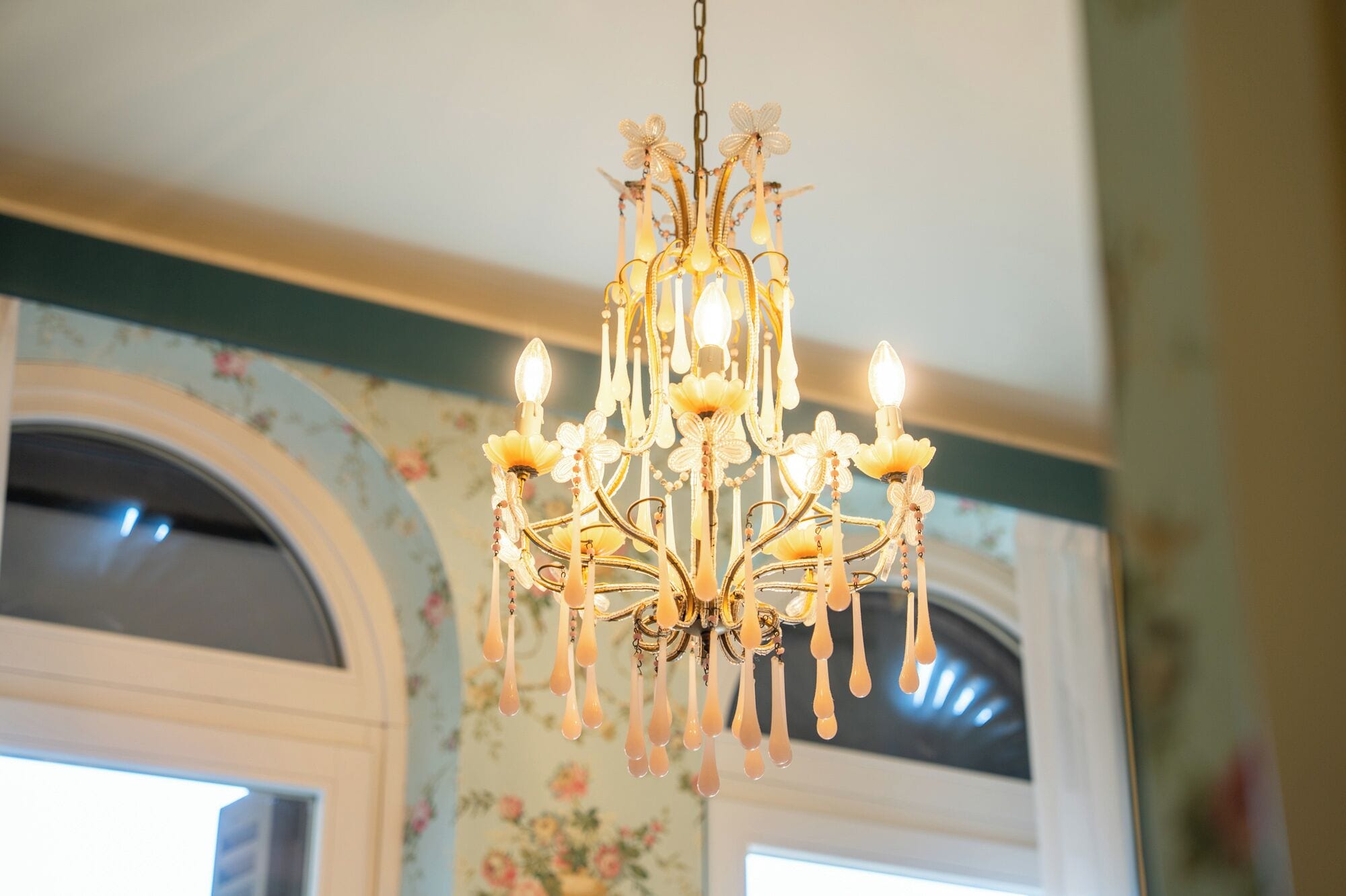 A chandelier with multiple lights and floral decorations.