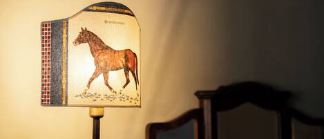 Una lámpara con un diseño de caballo en su pantalla.