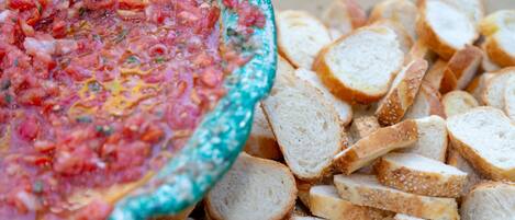 A bowl of salsa and sliced bread.