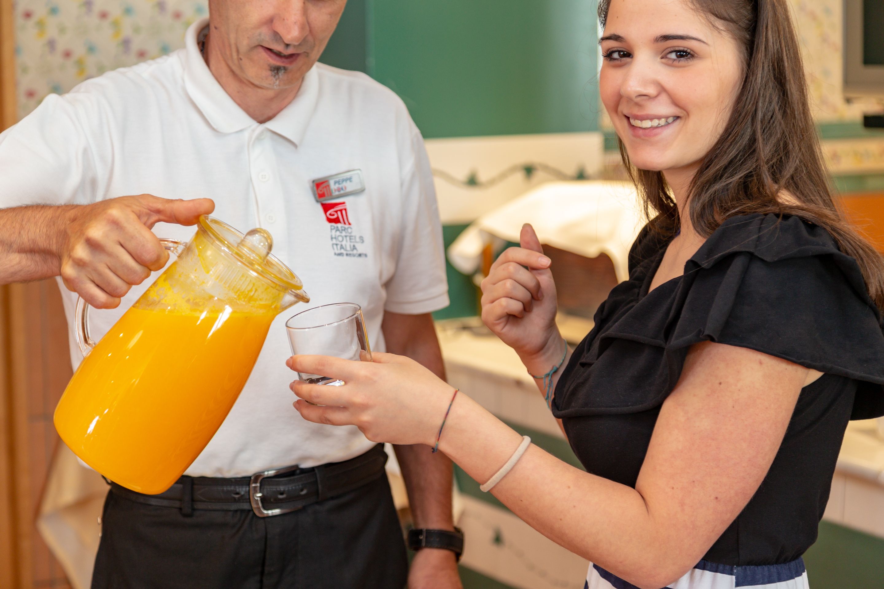 Eine Person gießt Orangensaft in ein Glas.