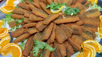 A plate of breaded and fried food garnished with orange slices and greens.