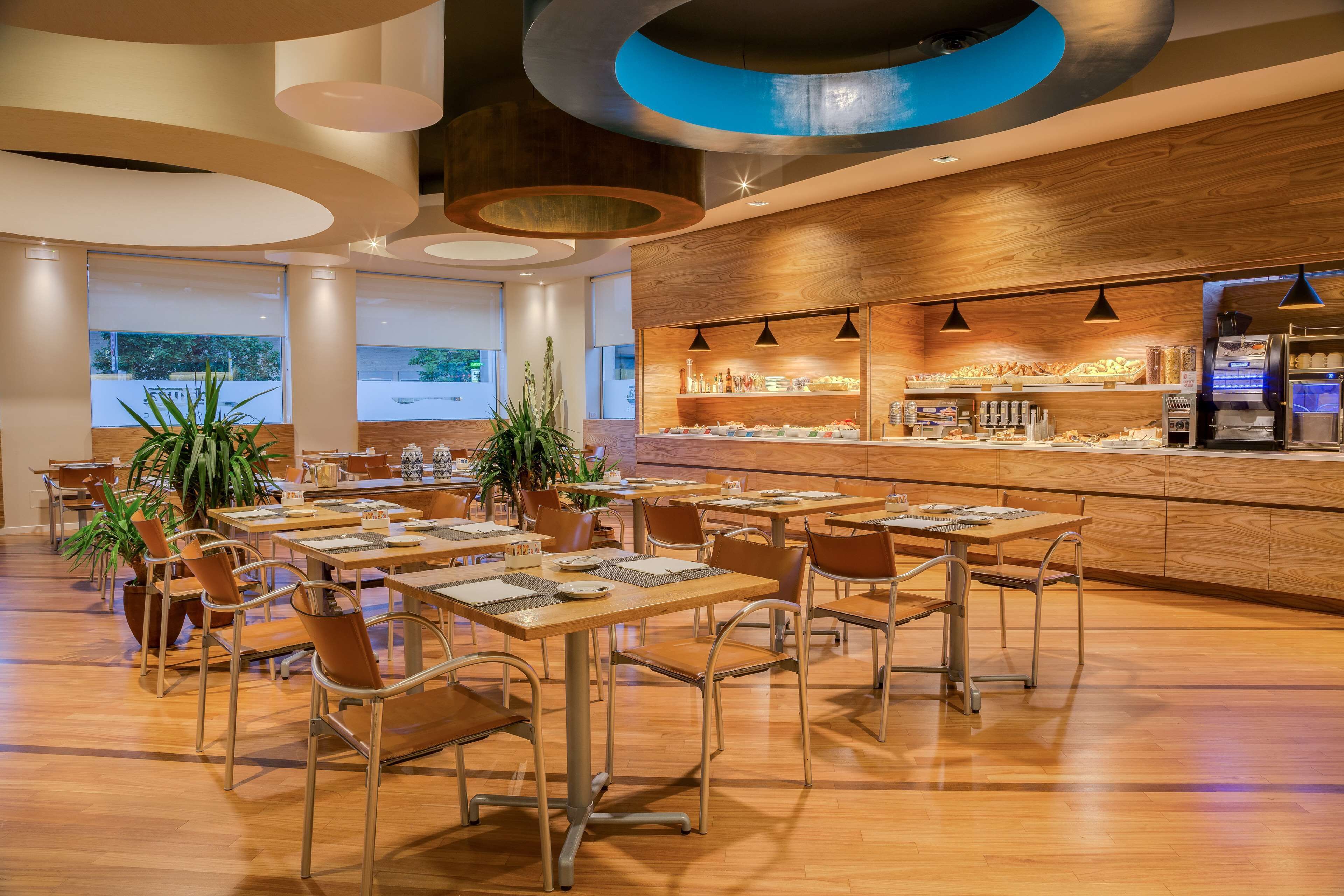 A modern restaurant with wooden accents, a bar area, and a view of the outdoors.