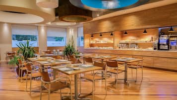 A modern restaurant with wooden accents, a bar area, and a view of the outdoors.