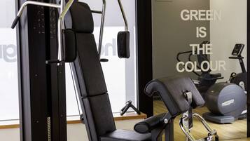 A gym with a weight machine, a bench, and a treadmill.