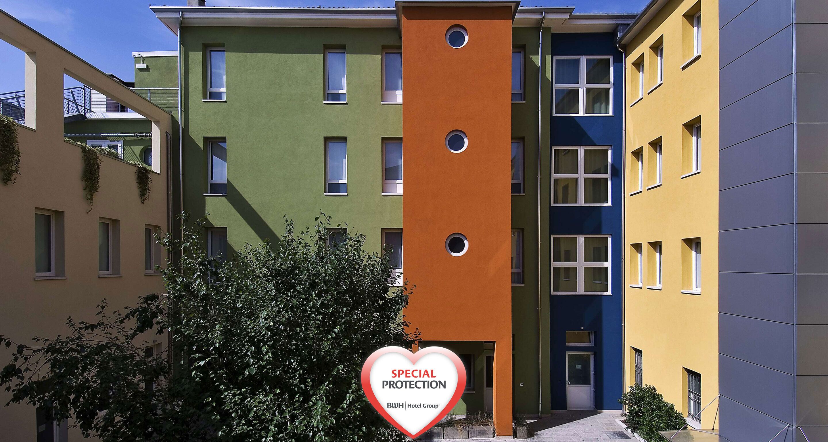 Un hotel de varios pisos con fachadas coloridas y un letrero que indica protección especial.
