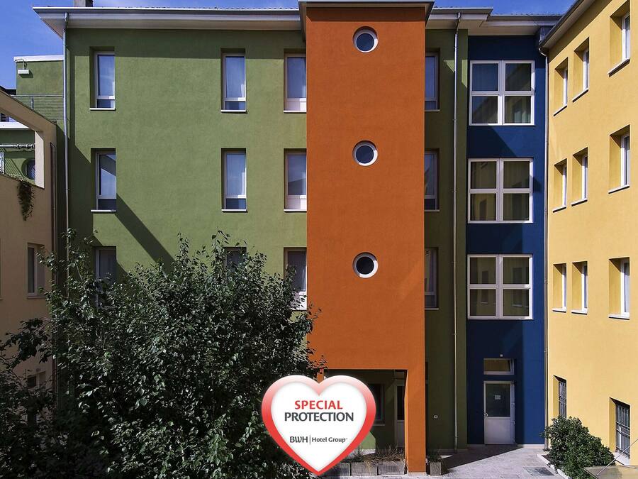 Un hotel de varios pisos con fachadas coloridas y un letrero que indica protección especial.