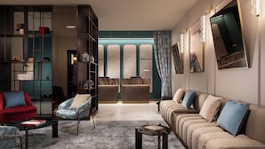 A modern living room with a sofa, armchairs, a coffee table, and a bookshelf. - Puccini Hotel Milan, Tapestry Collection by Hilton (Milan)