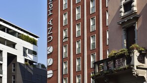 A hotel with a modern facade, multiple windows, and balconies with plants. - UNA Hotels Mediterraneo Milano (Milan)