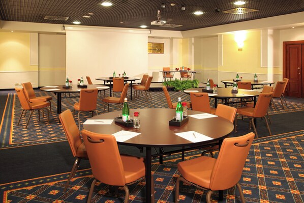 A conference room with multiple tables and chairs, equipped with water bottles and notepads. - Starhotels Business Palace (Milan)