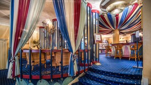 A grand staircase with blue carpet and red and white drapes. - Auriga Hotel (Milan)