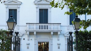 The entrance to Montecatini Palace with a symmetrical facade, two large windows with shutters, and a central entrance with a glass door. - LHP Hotel Montecatini Palace & SPA (Montecatini Terme)