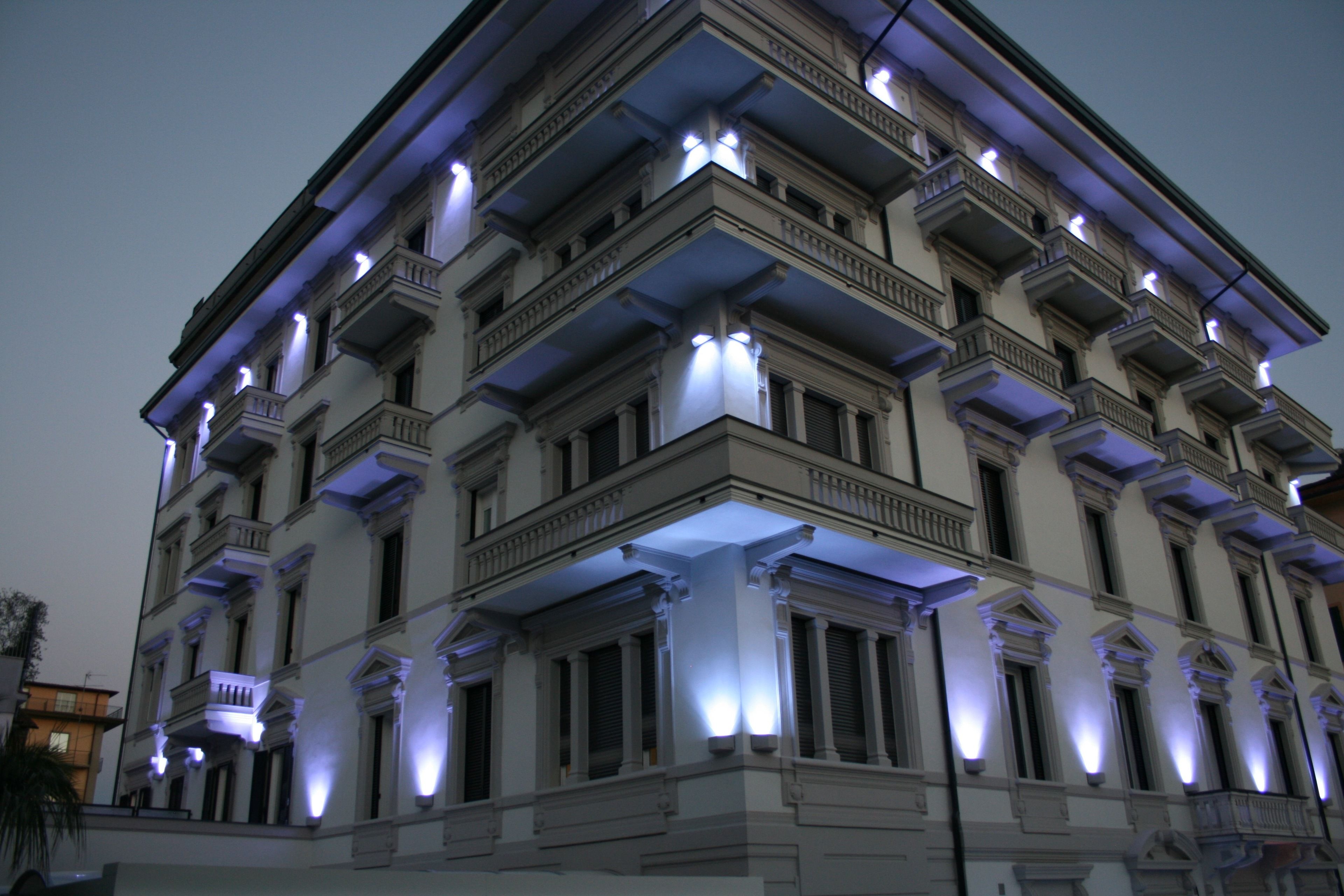 Ein mehrstöckiges Gebäude mit klassischer Architektur, mit Balkonen und beleuchteten Fenstern.