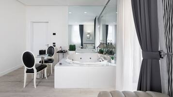 A modern bathroom with a large bathtub, a vanity, and a mirror.