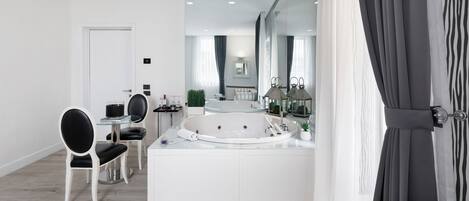 A modern bathroom with a large bathtub, a vanity, and a mirror.