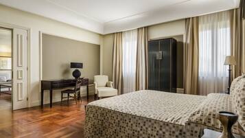 Una habitación de hotel con una cama grande, un escritorio con silla, un armario y una lámpara.