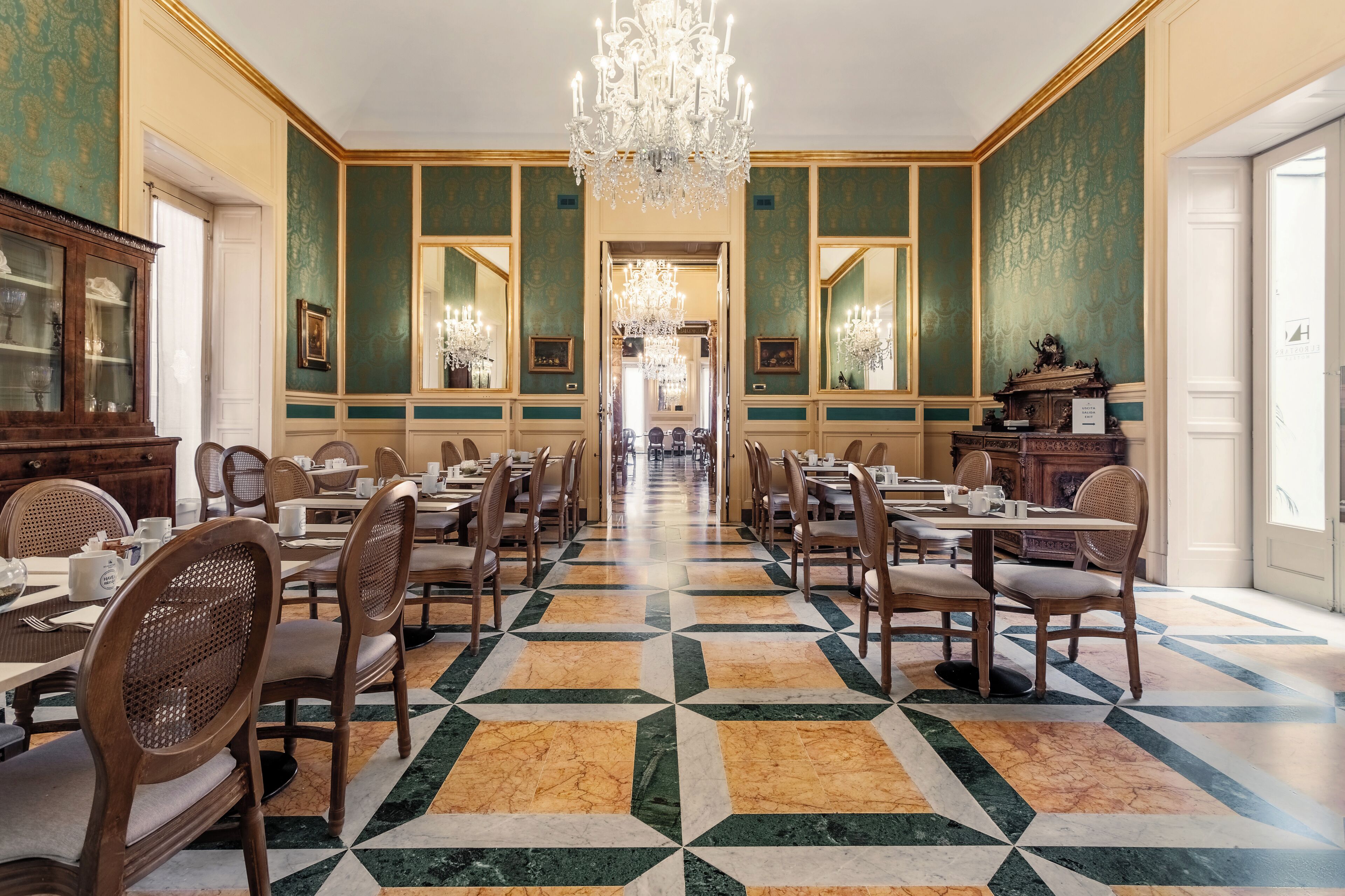 Une salle à manger élégante, avec de longues tables, des chaises et un lustre.