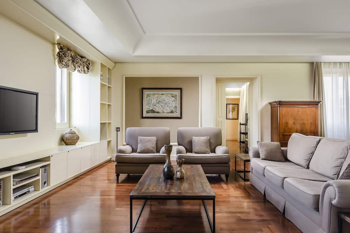A living room with a flat-screen TV, two sofas, a coffee table, and a cabinet.