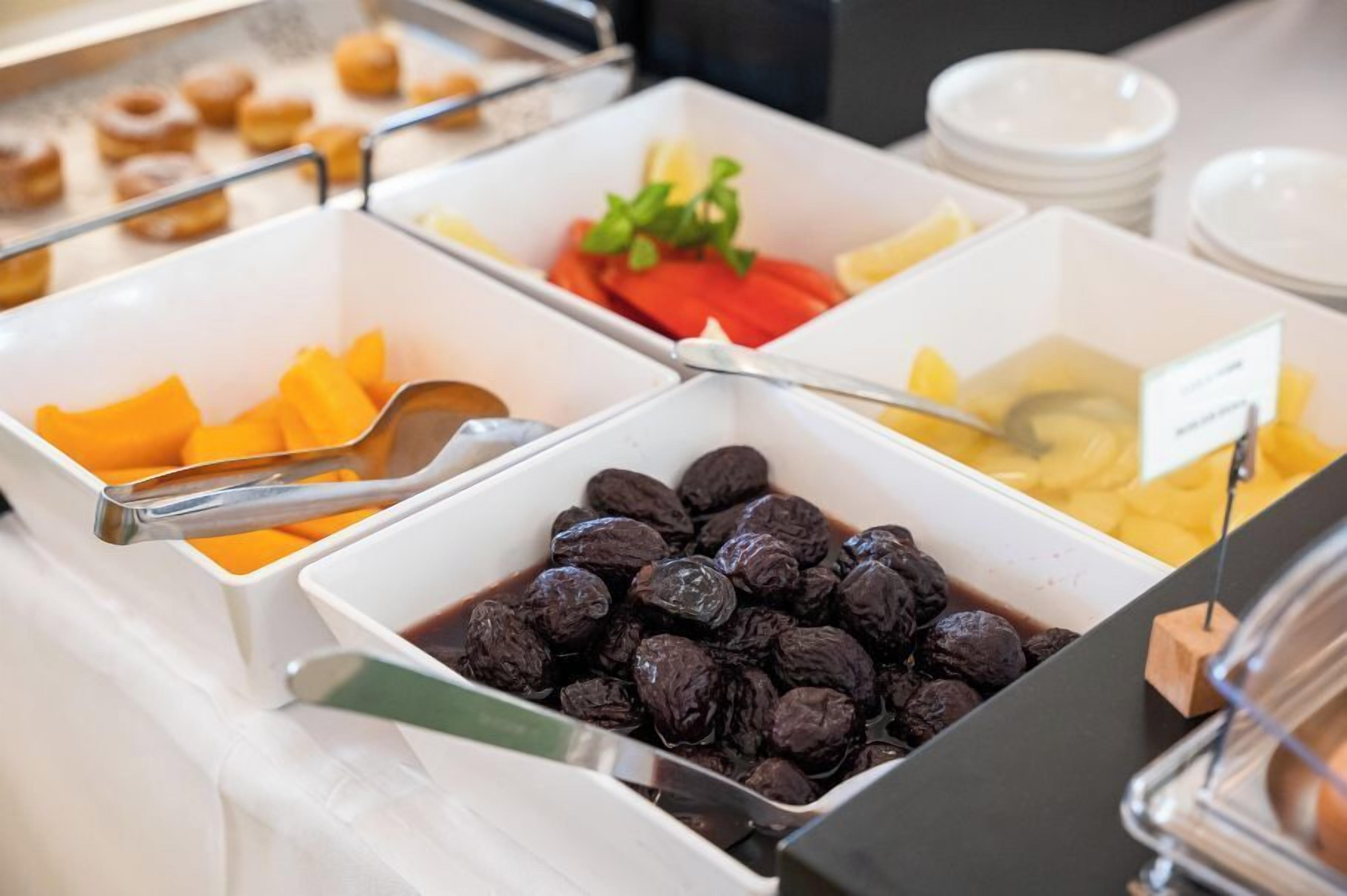 A buffet with various food items including fruits and nuts.