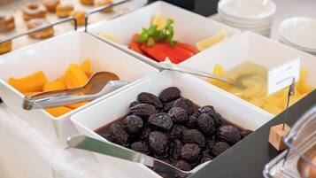 A buffet with various food items including fruits and nuts.