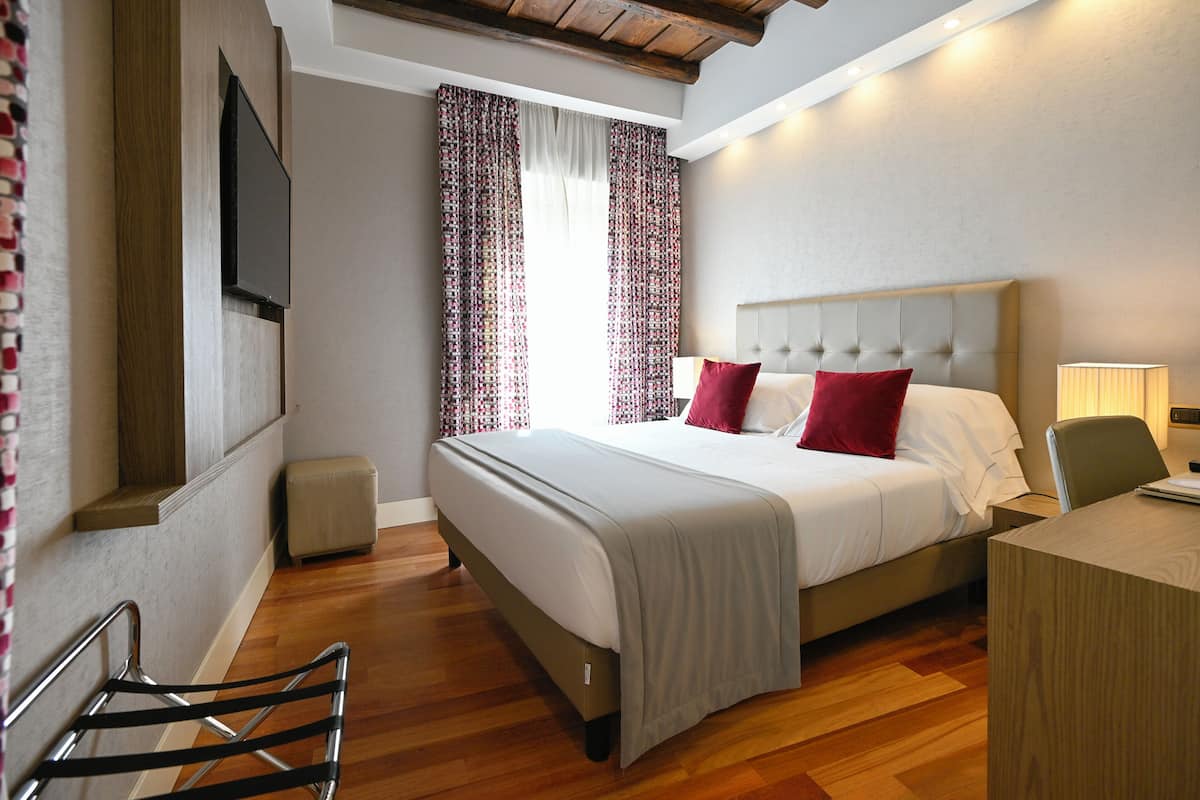 Una habitación de hotel moderna con una cama grande, un escritorio y una silla.
